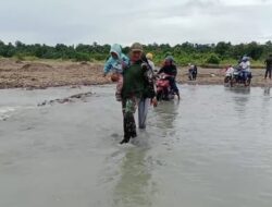 Babinsa membantu & mengarahkan masyarakat menyebrangi sungai yg banjir pasca hujan