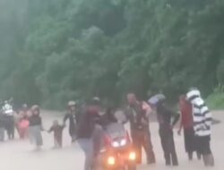 Babinsa membantu masyarakat menyebrangi sungai yg banjir