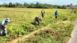 Babinsa Bergotong royong bersama warga desa membersihkan parit